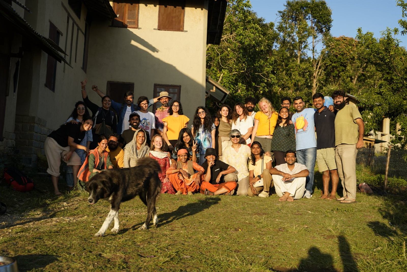 The workshop group in front of the earthen building at golden hour